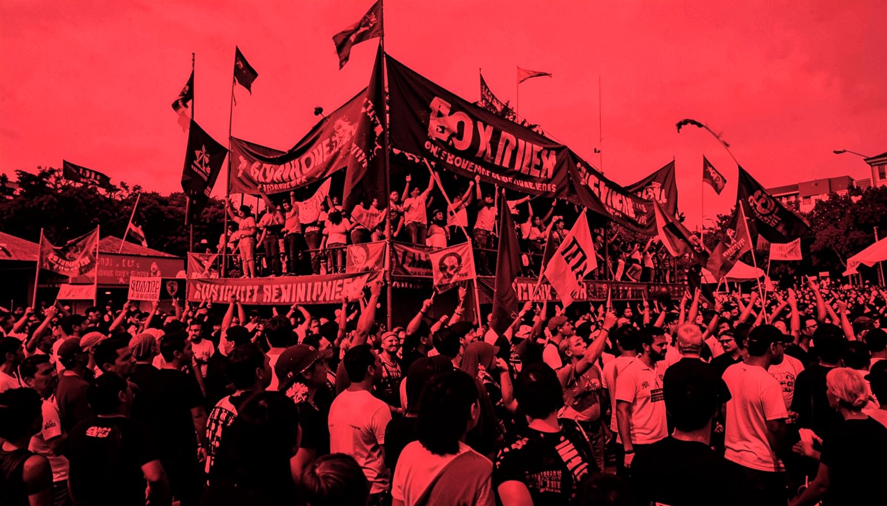 Duotone photograph in red and black of a vibrant parade float with banners and a crowd, conveying celebration and community pride