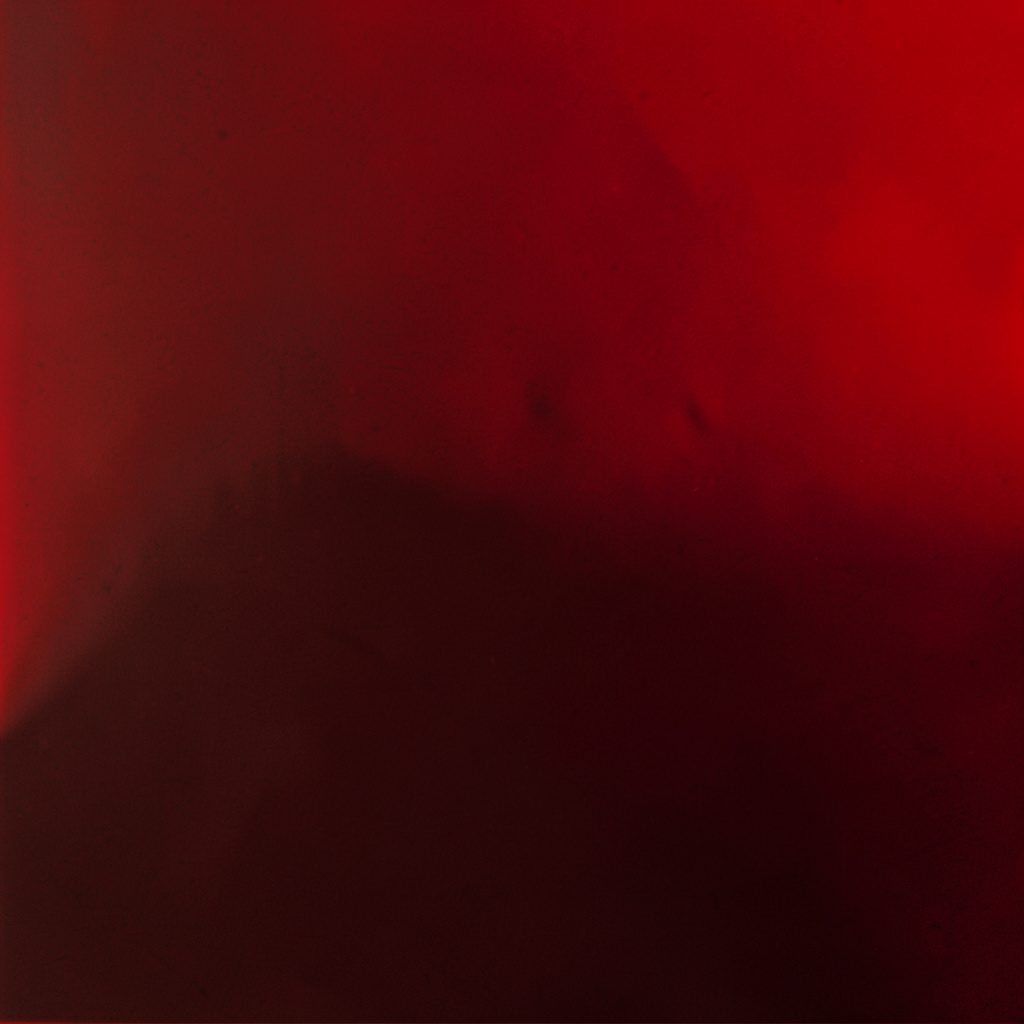 A vibrant group scene with warm red lighting, people laughing together